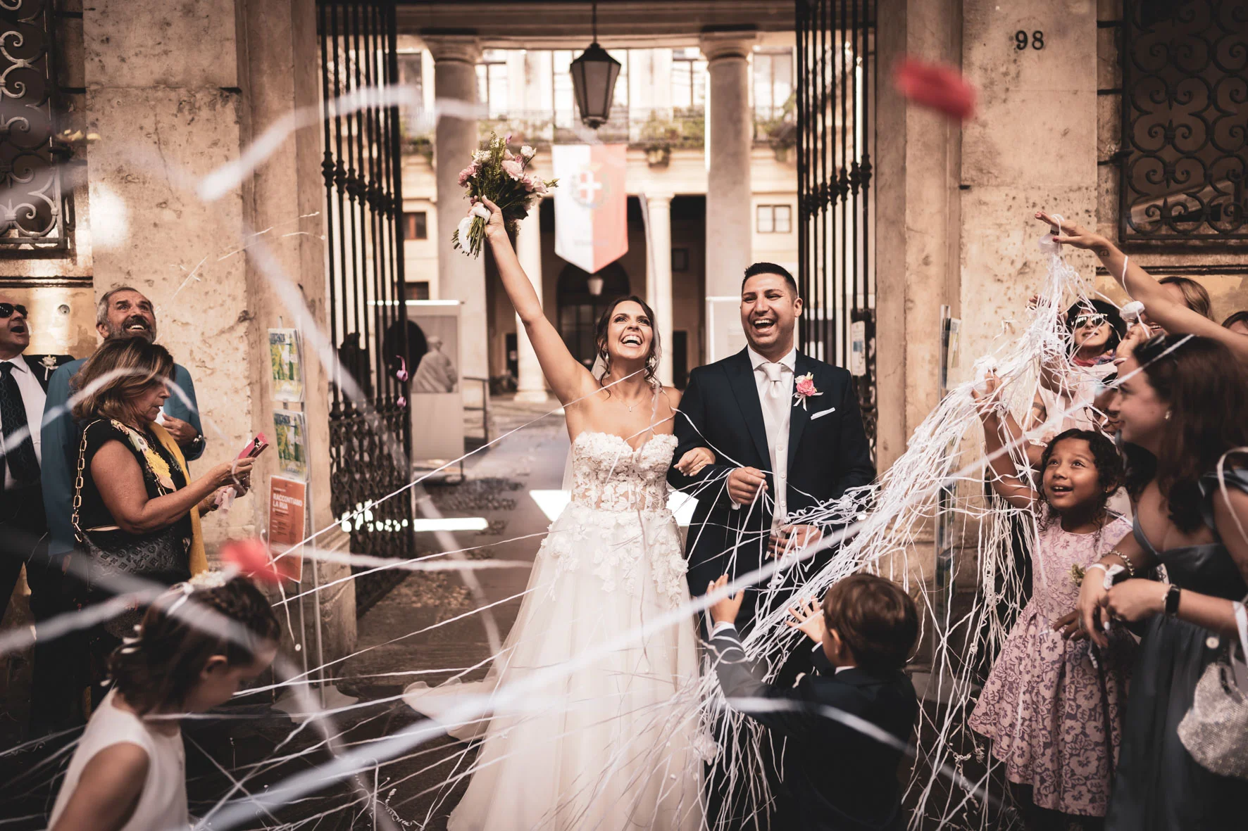 Gli sposi festeggiano all’uscita della cerimonia, tra nastri e abbracci
